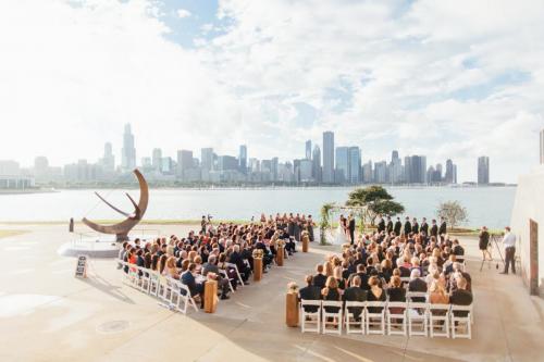 A shot of a wedding taking place right outside of the Adler, with the Chicago skyline in view in the background.